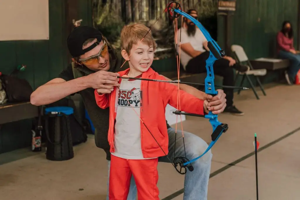 archery-teacher-teaches-young-boy-to-shoot-arrows