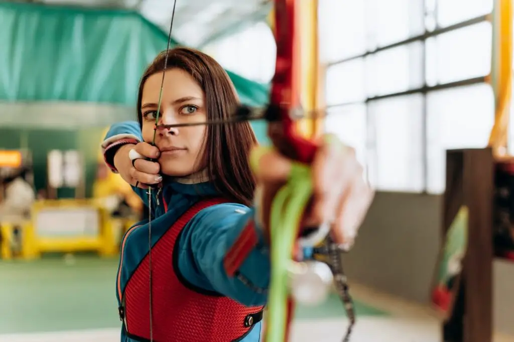 woman practicing archery indoor archery range