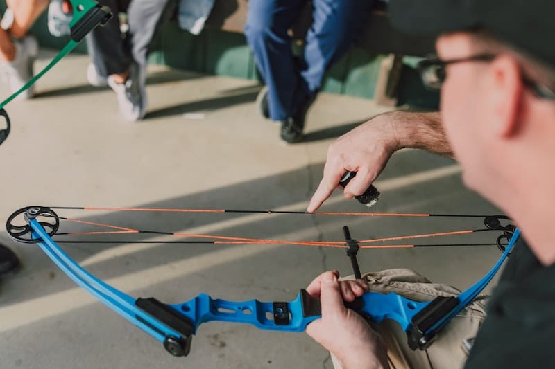 man-pointing-at-bow-string