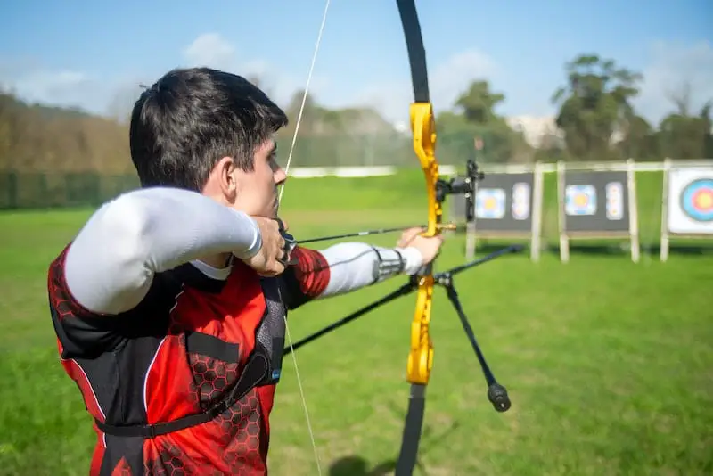 man doing archery on field with targets